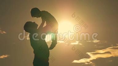 父亲和儿子在公园里玩耍，夕阳下，一个幸福的家庭<strong>剪影</strong>